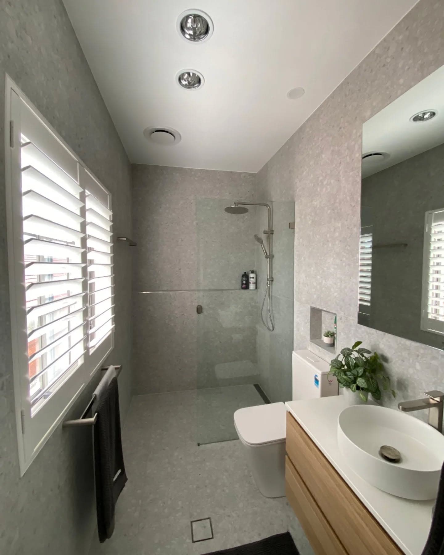 Modern bathroom with large-format grey tiles and frameless shower