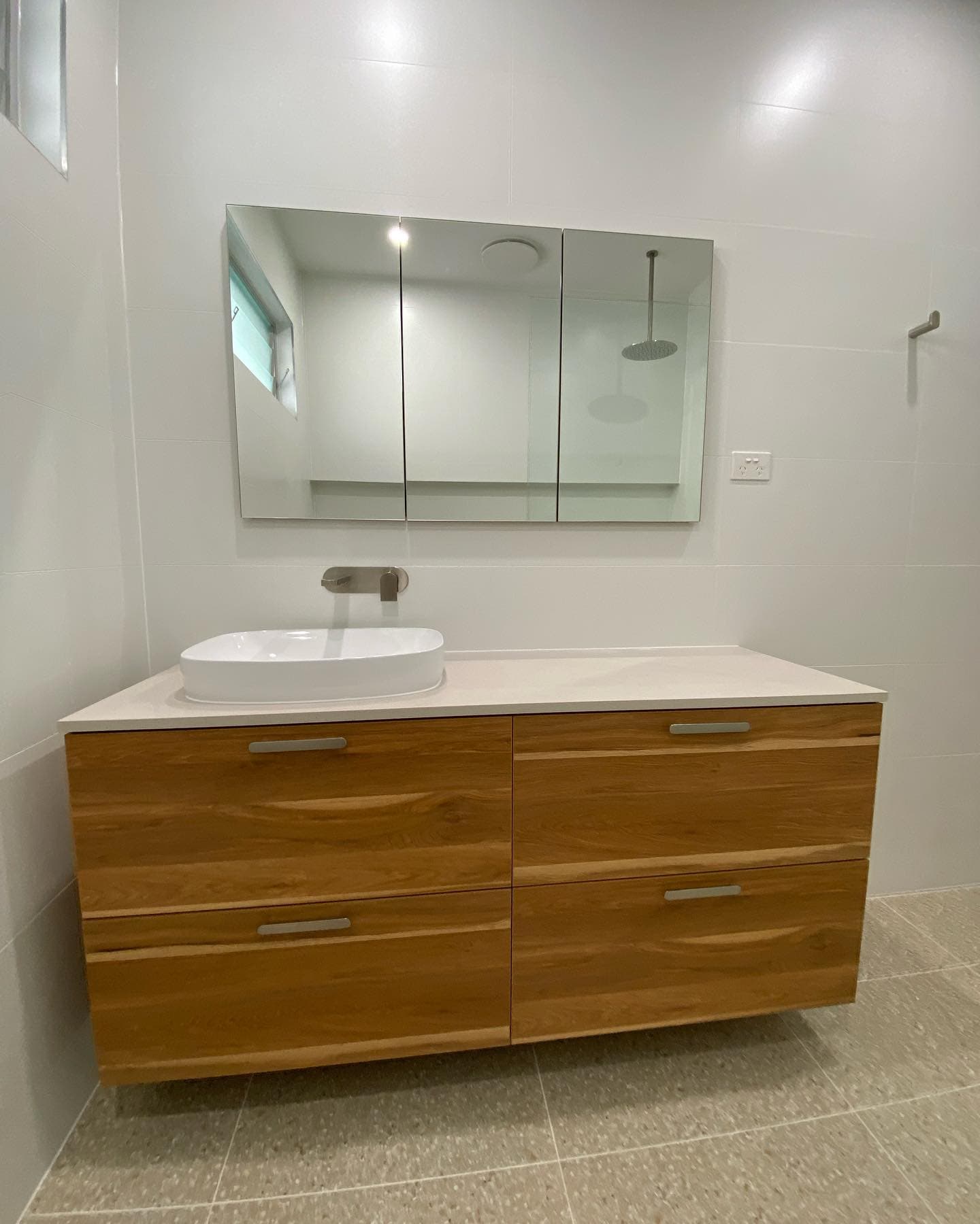 Bathroom with timber vanity, vessel basin and floor-to-ceiling tiling